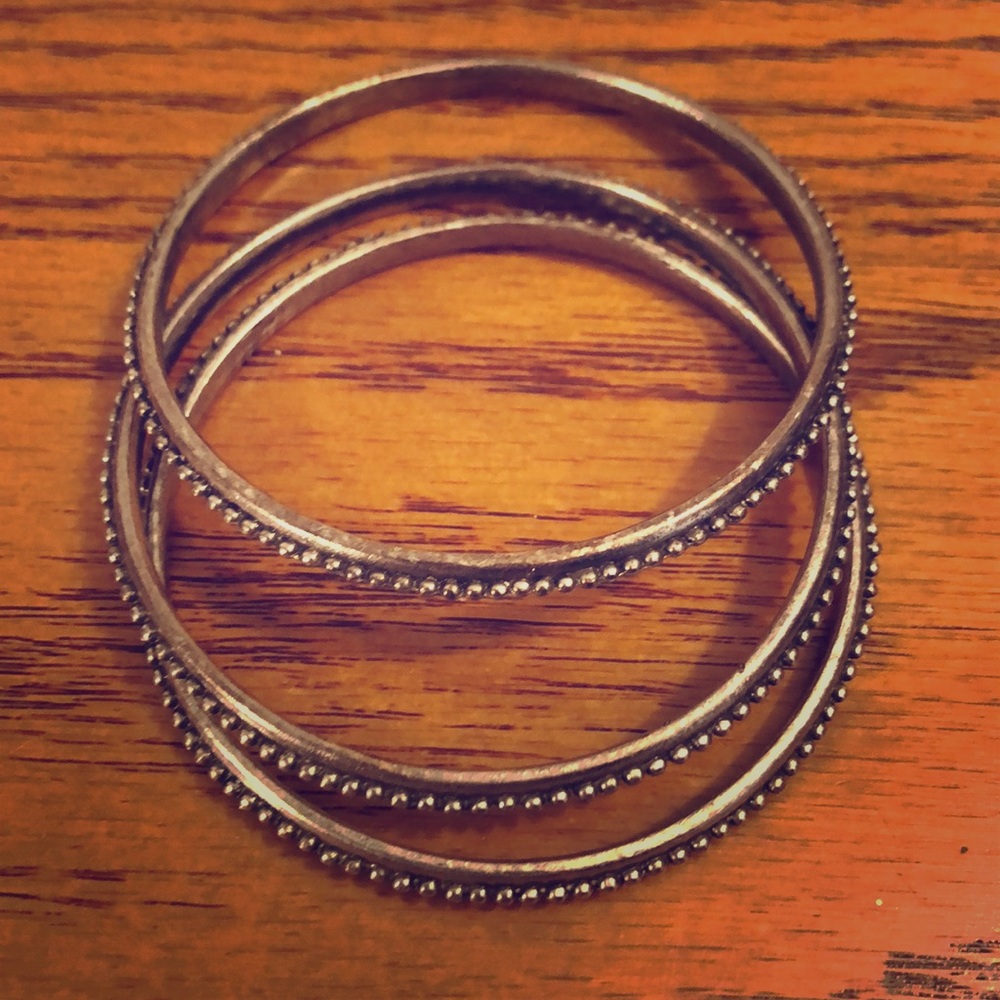 Three silver tone bangle bracelets.